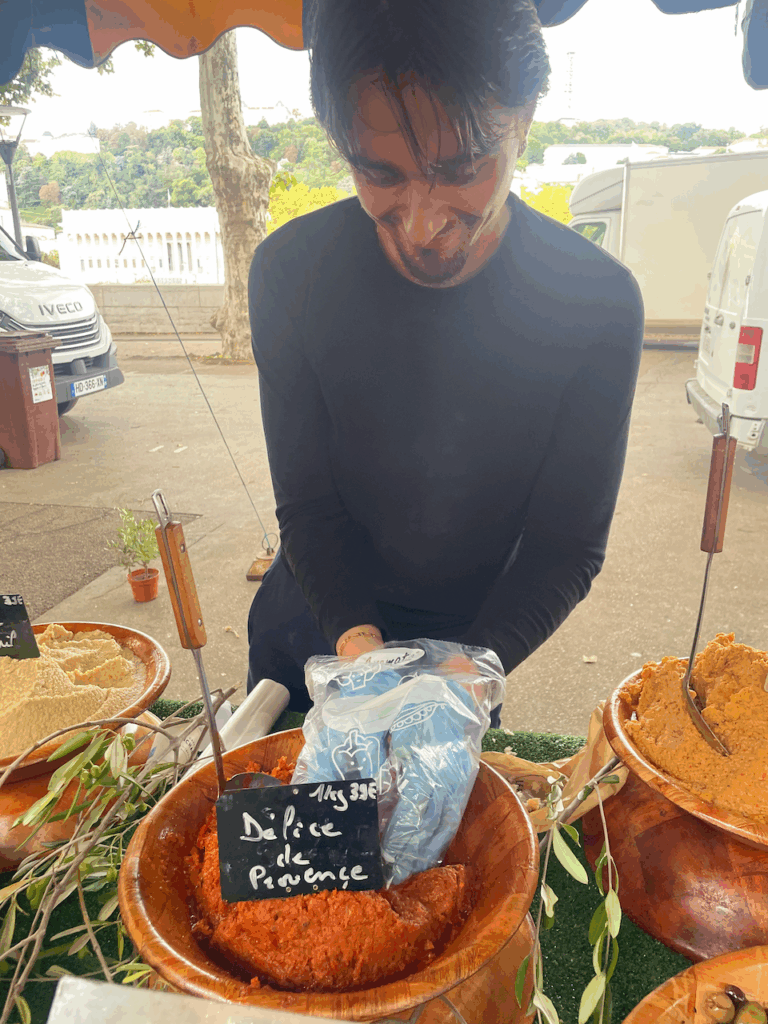 A man scoops "delice to provence" into a bag