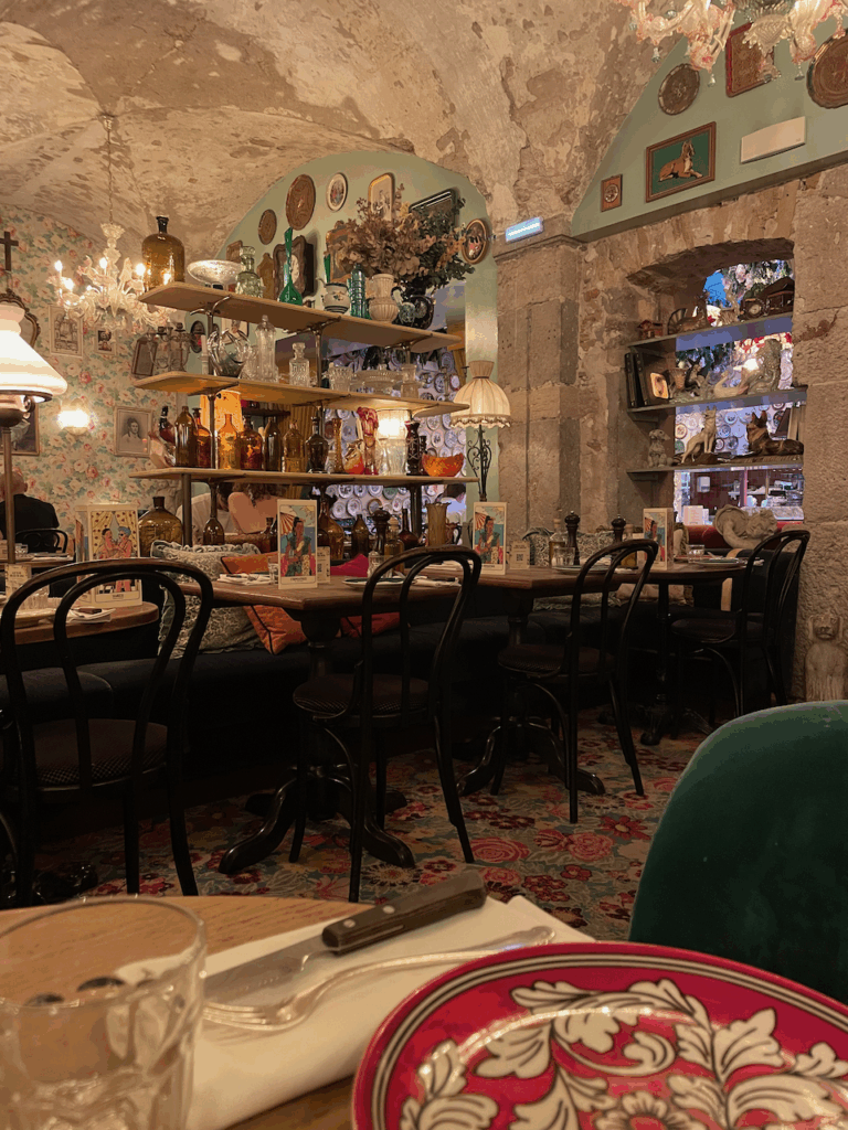 a restaurant with arched roof, with vases and other tchotchkes on shelves 