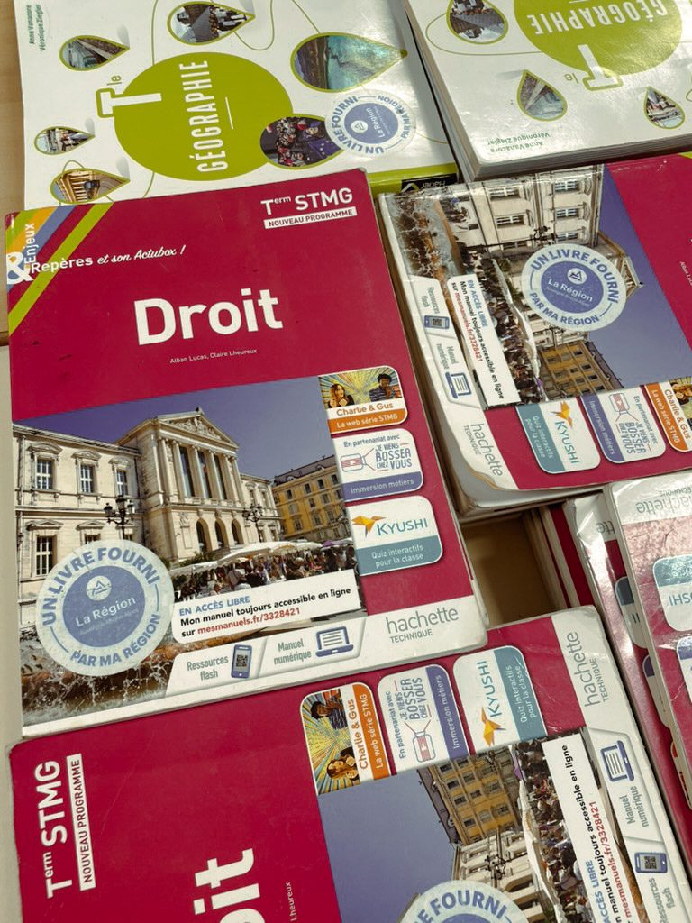 Textbooks for various subjects, including "Droit," arranged on a table. The covers feature images of buildings and logos related to educational programs.