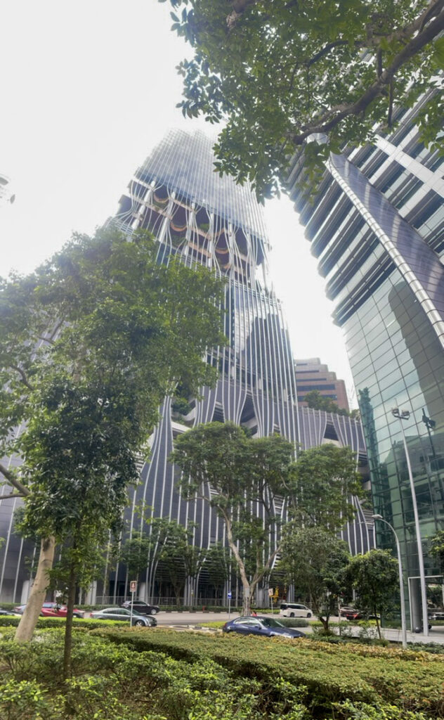 a vertical panorama of a skyscraper that has trees growing inside it
