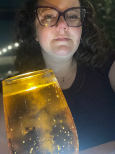 Hope behind a glass of cider with the fancy bubbles lit from below