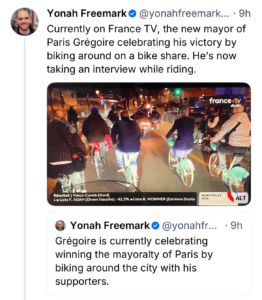 A post from Blue Sky: The new mayor of Paris, Grégoire, celebrates his election victory by biking through the city with supporters at night, while being interviewed. Bright lights and a festive atmosphere surround the group.